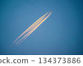 Contrails dyed by the setting sun in the blue sky 134373886