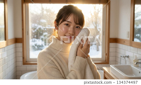 一位二十多歲的日本女性塗抹潤膚露後感覺略微滋潤 | 冬日清晨，略帶拉扯感的護膚品廣告風格 134374497