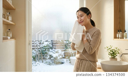 一位二十多歲的日本女性塗抹潤膚露後感覺略微滋潤 | 冬日清晨，略帶拉扯感的護膚品廣告風格 134374500