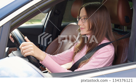 Confident smiling Caucasian woman female driver sitting inside new car. Confident smiling Caucasian woman female driver sitting inside new car. 134376121