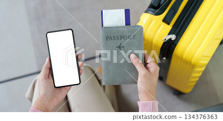 Travel Preparation. Woman holding phone and passport at the airport. Travel Preparation. Woman holding phone and passport at the airport. 134376363