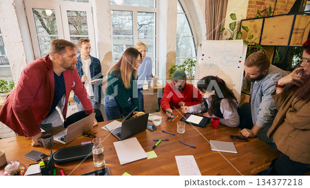 Startup team working together around table in modern office. 134377218