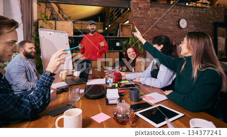 Coworkers brainstorming ideas in startup office environment. Coworkers brainstorming ideas in startup office environment. 134377241