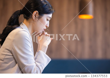 Woman thinking in a cafe 134377553