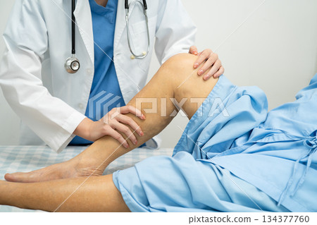 Doctor checking Asian elderly woman patient with scar knee replacement surgery in hospital. 134377760