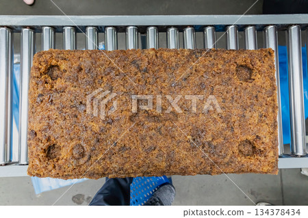 The natural rubber bales products on the industrial automatic conveyor belt machine in a rubber factory. 134378434