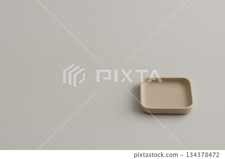 極簡主義構圖，一個小木托盤放置在米色背景上。 134378472