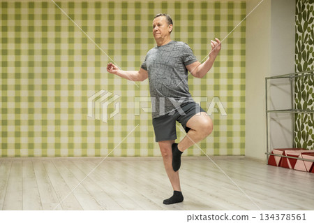 Tree pose balance by caucasian man in fitness studio mirror 134378561