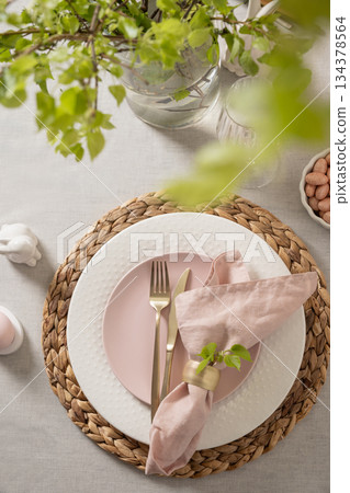 Easter table setting with bunny, pink plate and pastel eggs Easter table setting with bunny, pink plate and pastel eggs 134378564
