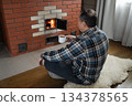 Relaxing by fireplace with hot drink at home 134378565