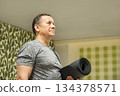 Adult man holding yoga mat before training. Senior Man Yoga. Stretching, Balance and Flexibility Training 134378571