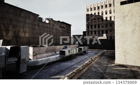 A quiet moment on a rooftop, showcasing contrasting buildings in an urban setting. Shadows cast across the flat surface, hinting at the bustling life below as afternoon light fades. 134378809