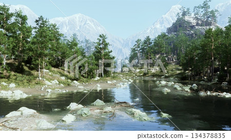 Lush green trees surround a calm river reflecting the mountains at dawn. Soft light enhances the tranquil scene, inviting peaceful moments in natures embrace. 134378835