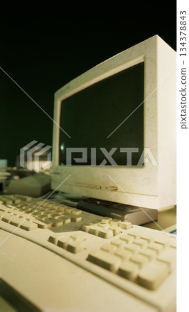 A dusty old computer sits idle in an abandoned room, its keyboard and monitor covered in layers of dust. The fading light creates an eerie atmosphere, hinting at forgotten memories. A dusty old computer sits idle in an abandoned room, its keyboard and monitor covered in layers of dust. The fading light creates an eerie atmosphere, hinting at forgotten memories. 134378843