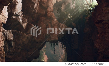 Bright rays of sunlight shine down into a tranquil canyon, illuminating vibrant green plants among rugged rocks. The scene evokes a sense of peace and connection with nature. Bright rays of sunlight shine down into a tranquil canyon, illuminating vibrant green plants among rugged rocks. The scene evokes a sense of peace and connection with nature. 134378852