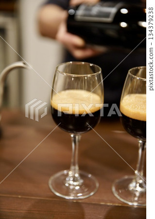Black beer poured into a wine glass Black beer poured into a wine glass 134379238