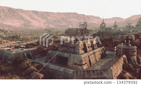 An expansive view of ruined structures stands in a vast, rocky terrain under a warm sunset. The mountains loom in the background, evoking a sense of hidden stories and forgotten times. An expansive view of ruined structures stands in a vast, rocky terrain under a warm sunset. The mountains loom in the background, evoking a sense of hidden stories and forgotten times. 134379392