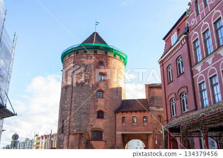 Historic tower stands tall next to buildings in city during daylight hours Historic tower stands tall next to buildings in city during daylight hours 134379456