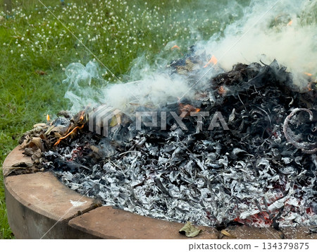 dangerously hot orange and red flames with dense black smoke consuming wood and embers dangerously hot orange and red flames with dense black smoke consuming wood and embers 134379875