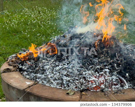 dangerously hot orange and red flames with dense black smoke consuming wood and embers dangerously hot orange and red flames with dense black smoke consuming wood and embers 134379906