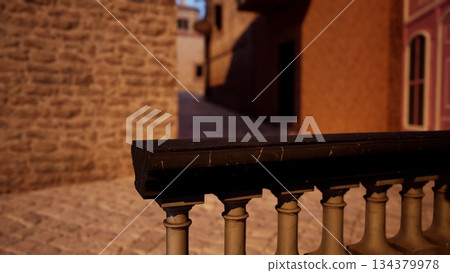 A quiet cobblestone alleyway just after sunset. Warm light illuminates the stone walls, creating a peaceful atmosphere. The distant buildings add to the cozy charm of the setting. 134379978