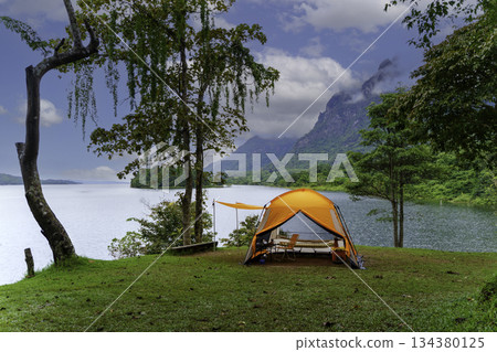 Summer camping adventure in the forest with a tent among green trees and grass 134380125