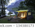 Camping tent on green grass in the morning, antique gas lamps, retro chairs, with outdoor coffee-making facilities on tables in a forest camping area. 134380173