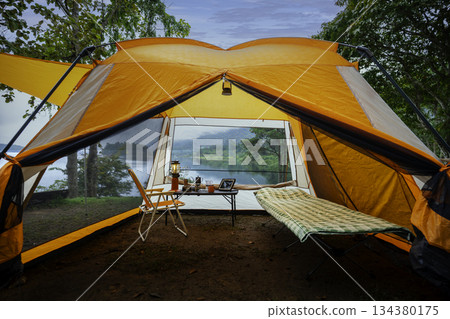Camping tent, view from inside the tent to see the view outside the mountain, forest, lake, camping tent on a high mountain 134380175