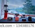 Coffee drip set for camping inside a tent, looking out to the mountain and lake view. 134380176