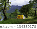 Camping tent on green grass in the morning, antique gas lamps, retro chairs, with outdoor coffee-making facilities on tables in a forest camping area. 134380178