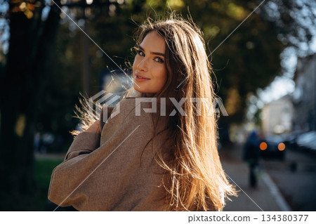 Focused portrait. Beautiful woman is outdoors in the town Focused portrait. Beautiful woman is outdoors in the town 134380377