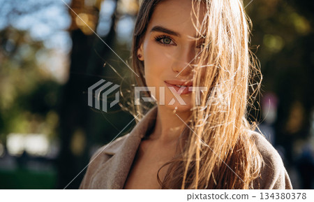 Focused portrait. Beautiful woman is outdoors in the town Focused portrait. Beautiful woman is outdoors in the town 134380378