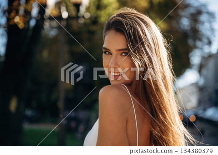 Under sunlight. Beautiful woman is outdoors in the town Under sunlight. Beautiful woman is outdoors in the town 134380379