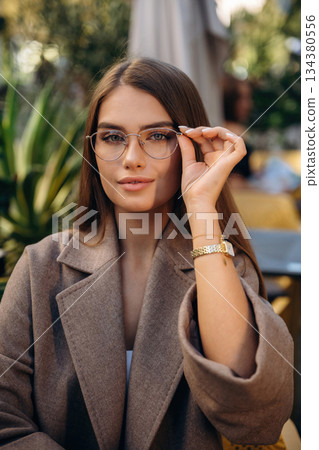 Wearing the glasses. Pretty young woman is outdoors Wearing the glasses. Pretty young woman is outdoors 134380556