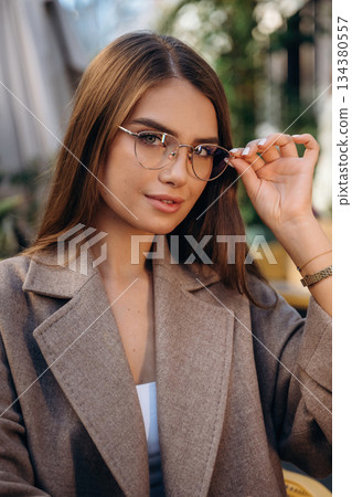 Wearing the glasses. Pretty young woman is outdoors Wearing the glasses. Pretty young woman is outdoors 134380557