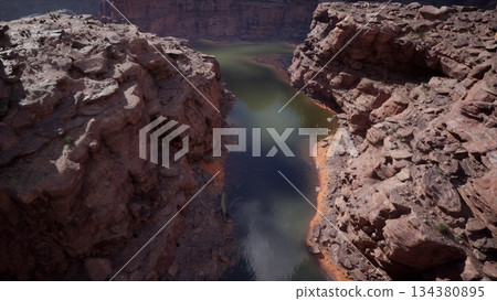 Breathtaking scene captures the winding river snaking through rugged rocky canyons during a tranquil day. The sunlight glimmers on the waters surface, highlighting natures beauty. Breathtaking scene captures the winding river snaking through rugged rocky canyons during a tranquil day. The sunlight glimmers on the waters surface, highlighting natures beauty. 134380895
