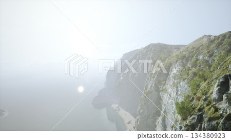 Morning light softly illuminates the rugged cliffs overlooking a calm ocean. Waves gently lap at the shore, while lush greenery adds vibrant color to the landscape. Morning light softly illuminates the rugged cliffs overlooking a calm ocean. Waves gently lap at the shore, while lush greenery adds vibrant color to the landscape. 134380923