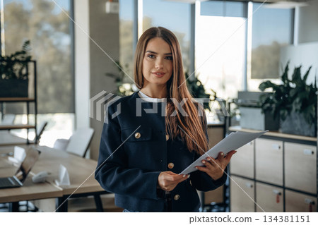 Documents in hands, papers. Beautiful woman is working in the office Documents in hands, papers. Beautiful woman is working in the office 134381151