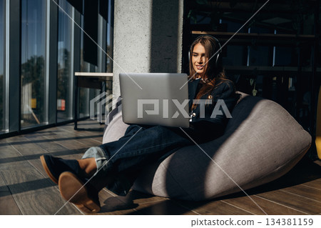 Woman is sitting and working by using laptop 134381159