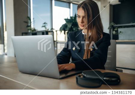 By a laptop. Woman is working in the office By a laptop. Woman is working in the office 134381170