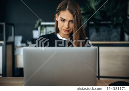 By a laptop. Woman is working in the office By a laptop. Woman is working in the office 134381171