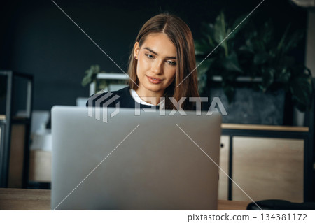 By a laptop. Woman is working in the office By a laptop. Woman is working in the office 134381172