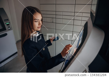 Woman is using banking terminal indoors 134381204