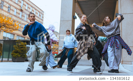 Hip hop dancers rehearsing routine together in urban location. 134381612
