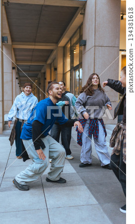 Young hip hop dancers practicing together near modern office buildings. Young hip hop dancers practicing together near modern office buildings. 134381618