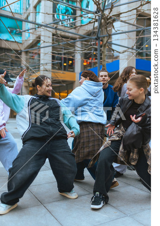Hip hop dancers practicing moves in city walkway during casual rehearsal. Hip hop dancers practicing moves in city walkway during casual rehearsal. 134381628