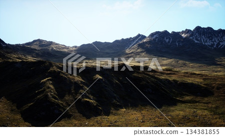 Majestic mountains rise against a brilliant blue sky, illuminated by warm afternoon sunlight. Lush green valleys extend between rocky peaks, showcasing natures beauty and tranquility. Majestic mountains rise against a brilliant blue sky, illuminated by warm afternoon sunlight. Lush green valleys extend between rocky peaks, showcasing natures beauty and tranquility. 134381855
