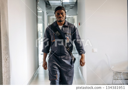 In the corridor. Repairman is indoors in the modern office 134381951