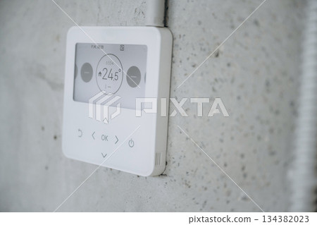 Thermostat on the wall, showing current temperature in the room 134382023