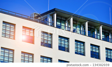 Office building in loft style. Facade of commercial office with windows. White walls of an industrial building. 134382039